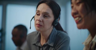 Çevrimiçi müşteri destek servisi: İki kadın teknik destek uzmanının kulaklıklarda müşteriyle sohbet etmesi. Modern çağrı merkezinde çalışan profesyonel yardım hattı operatörleri.
