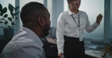 Modern ve donanımlı çağrı merkezi: Çok ırklı teknik müşteri destek uzmanlarından oluşan ekip öğle yemeğinde pizza dağıtımı yapıyor ve yiyor. Bir grup şirket çalışanı işten izin alırken dinleniyor..