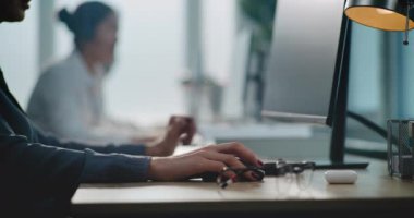 Modern çağrı merkezi: Kafkas kadın teknik destek uzmanını kapatın bilgisayar üzerinde çalışıyor, kulaklıkla konuşuyor. Çevrimiçi müşteri hizmetleri sağlayan yardım hattı operatörlerinden oluşan çok ırklı bir ekip.