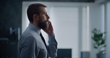 Modern ofis odası: Ofis çalışanının ayakta duran ve ortaklarıyla telefonla konuştuğu yan manzara. İş adamı telefon görüşmesinde başarısız iş anlaşmasıyla ilgili kötü haberler alır. Finansal kriz ya da kovulma.