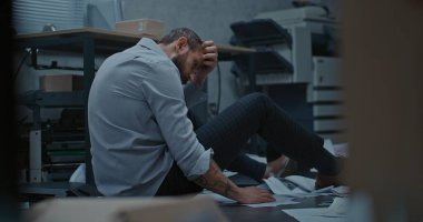 Depresyondaki işadamı, başarısız iş anlaşmasından sonra öfke nöbeti geçirdikten sonra yerde oturuyor. Üzgün ofis çalışanı ofis odasını dağıttıktan sonra derin derin nefes alıyor. Finansal kriz ya da kovulma. İş patlaması.