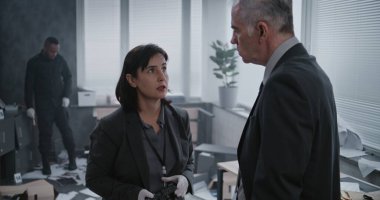 Ofis soygunu, olay yerinde olay yeri inceleme ekibi. Kadın kriminalist ipuçlarının ve kanıtların fotoğraflarını çeker, sonra da erkek dedektifle konuşur. Arka planda Afro-Amerikan polisi çalışıyor..