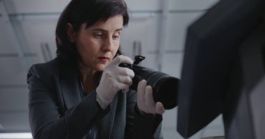 Ofis soygunu ya da cinayet davası: kadın suç uzmanının suç mahallinde profesyonel kamerayla fotoğraf çekmesi. Erkek dedektif gelir, iş arkadaşıyla konuşur. Araştırma ekibi çalışıyor..