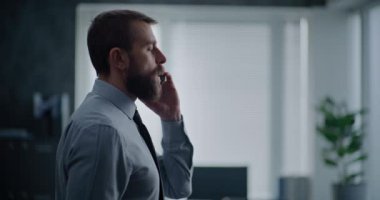 Modern ofis odası: Ofis çalışanının ayakta duran ve ortaklarıyla telefonla konuştuğu yan manzara. İş adamı telefon görüşmesinde başarısız iş anlaşmasıyla ilgili kötü haberler alır. Finansal kriz ya da kovulma.