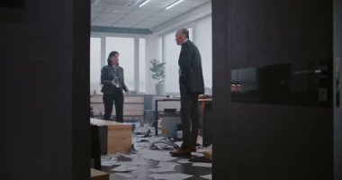 Ofis odasındaki soygun vakası: Suç araştırma ekibi olay yerinde çalışıyor. Kadın kriminalist telefonda konuşuyor, erkek dedektifle ipuçlarını tartışıyor. Afrikalı Amerikalı polis parmak izi buldu..