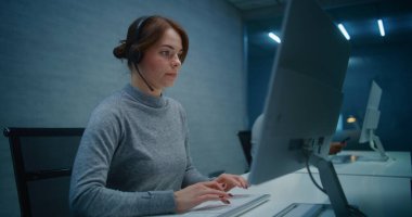 Gece Çağrı Merkezi Ofisi: Kulaklık izleme konusunda ciddi kadın teknik destek uzmanı, PC üzerinden verileri, çağrı yoluyla çevrimiçi müşteri destek hizmeti sunar. Çoklu etnik yardım hattı operatörleri ekibi çalışıyor.