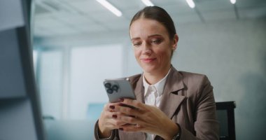 Kadın pazarlama uzmanı ya da E-ticaret müdürü iş yerinde oturuyor, iş ortağı ya da müşterisiyle akıllı telefon kullanarak sohbet ediyor. Kafkasyalı iş kadını E-ticaret şirketinin modern ofisinde çalışıyor..