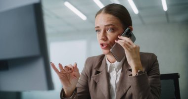 Kafkasyalı iş kadını, müşterisiyle ya da iş ortağıyla cep telefonu kullanarak agresif bir şekilde konuşur, bilgisayar ekranına bakar. Modern ofiste pazarlama müdürü veya finans uzmanı olarak çalışıyor. E-ticaret.