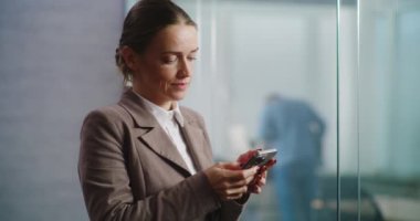 Kafkasyalı başarılı iş kadını iş ortağıyla kurye uygulamasında sohbet ediyor ya da cep telefonuyla müşteriye danışıyor. E-ticaret şirketinin modern, donanımlı ofisinde çalışan kadın pazarlama uzmanı..