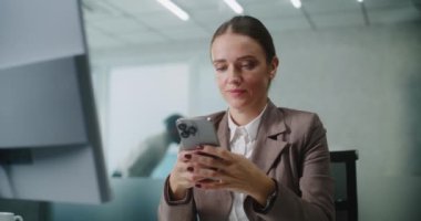 Kadın pazarlama uzmanı ya da E-ticaret müdürü iş yerinde oturuyor, iş ortağı ya da müşterisiyle akıllı telefon kullanarak sohbet ediyor. Kafkasyalı iş kadını E-ticaret şirketinin modern ofisinde çalışıyor..