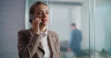 Kafkasyalı başarılı iş kadını iş stratejisini ortağıyla tartışıyor ya da cep telefonuyla müşterisine danışıyor. E-ticaret şirketinin modern ve donanımlı ofisinde çalışan kadın pazarlama uzmanı..