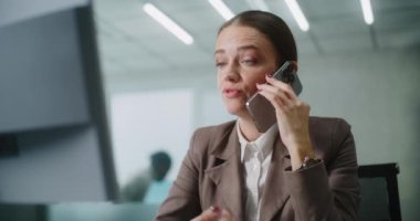 Kafkasyalı iş kadını, müşterisiyle ya da iş ortağıyla cep telefonu kullanarak agresif bir şekilde konuşur, bilgisayar ekranına bakar. Modern ofiste pazarlama müdürü veya finans uzmanı olarak çalışıyor. E-ticaret.