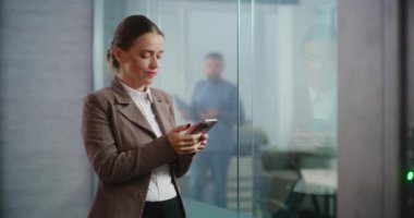 Kafkasyalı başarılı iş kadını iş ortağıyla kurye uygulamasında sohbet ediyor ya da cep telefonuyla müşteriye danışıyor. E-ticaret şirketinin modern, donanımlı ofisinde çalışan kadın finans uzmanı..