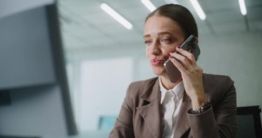 Pozitif kadın pazarlama uzmanı ya da E-ticaret müdürü iş ortağıyla konuşur, cep telefonuyla müşteriye danışır, bilgisayar kullanır. Kafkasyalı iş kadını modern ofiste çalışıyor. E-iş.