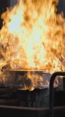 Metali kritik sıcaklığa ısıtarak çelik sertleştirme işleminin yavaş hareketi. Metal ürünlerin üretimi. Profesyonel endüstriyel ekipman. Dikey çekim