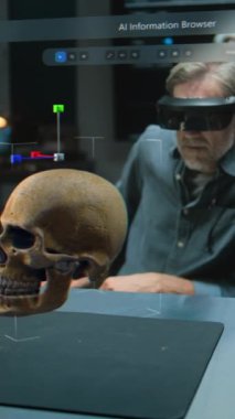 VR kulaklıklı dikey çekim arkeoloğu fosil kafatası ve antik insan anatomisini geliştirilmiş gerçeklik kullanarak inceliyor. Yapay zeka asistanı ve web tarayıcısıyla üç boyutlu sanal görüntü grafikleri. VFX