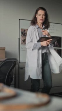 İki arkeolog ileri arkeoloji laboratuvarında çalışıyor. Olgun bilim adamı, tarih öncesi insan iskeletinin fosil kemiklerini bayan meslektaşına gösteriyor. Kadın tablet bilgisayar kullanıyor. Dikey çekim