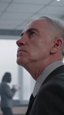 Ofis soygunu vakası, olay yerini inceleyen erkek dedektifin dikey çekimi. Kadın adli tıp uzmanının kanıt ve ipuçlarının fotoğraflarını çekmesi, Afro-Amerikan polisinin