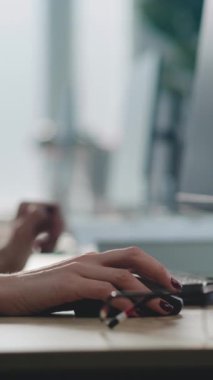 Modern çağrı merkezi: Kafkas kadın teknik destek uzmanının bilgisayar üzerinde çalışırken, kulaklıkla konuşurken dikey çekimi. Çevrimiçi müşteri sağlayan çok ırklı yardım hattı operatörleri ekibi