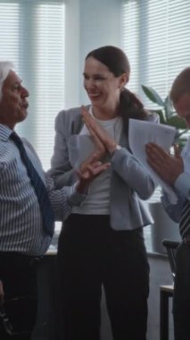 Borsa şirketinin modern ofisinde: Mutlu, heyecanlı pazarlama profesyonelleri ya da finans uzmanlarından oluşan bir ekip yatırım gününden sonra başarılı iş anlaşmalarını kutluyor. Dikey çekim