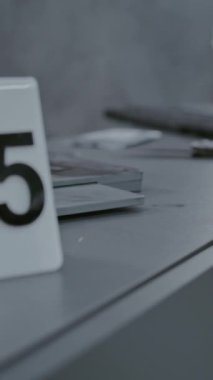 Soygun ya da cinayet davası: Numaralı işaretleyici olay yeri kanıtlarının yanında duruyor. Cinayet silahında manyetik toz kullanarak parmak izi taraması yapan kriminalist ya da adli tıp uzmanına yakın durun..