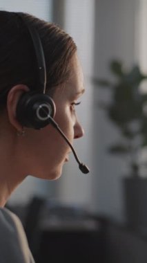 Dikey çekim ciddi borsa simsarı kulaklıkla bilgisayar başında çalışıyor. Profesyonel borsacı iş müşterisiyle iletişim kuruyor, hisseleri ve borsayı izliyor. Finans ve ticaret.