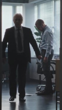 Bankanın ya da finans şirketinin modern ofisinde kızgın patron, başarısız iş anlaşmasından dolayı şirket çalışanına bağırır, kağıtları atar ve gider. Stresli adam iş yerinde oturur. Dikey