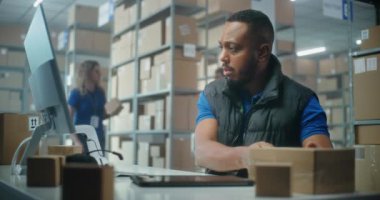 Afrikalı Amerikalı postane çalışanı karton paketleri barkod tarayıcı kullanarak tarıyor, bilgisayarla çalışıyor. Teslimat için kutuları müşterilere taşıyan tasnif merkezi çalışanları. Çevrimiçi E-ticaret mağazası deposu.