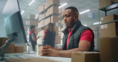 Afrikalı Amerikalı postane çalışanı karton paketleri barkod tarayıcı kullanarak tarıyor, bilgisayarla çalışıyor. Teslimat için kutuları müşterilere taşıyan tasnif merkezi çalışanları. Çevrimiçi mağaza. Yavaş çekim