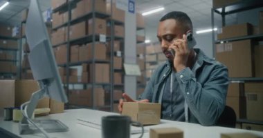 Posta servisi deposu veya E-ticaret mağazası: Afro-Amerikan lojistik koordinatörü telefonla konuşur, paketleri kontrol eder, bilgisayar kullanır. Sıralama merkezi çalışanı karton kutularla çalışır.