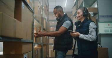 Teslimat Teslimat Merkezi 'nde çalışan çok ırklı Depo Ortakları: Kulaklık Taramasında Kadın Çalışanlar E-Ticaret Çevrimiçi Mallarla Karton Paketler, Akıllı Telefon Kullanımı, Bilgi Bilgilerini Denetler.