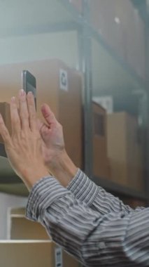 Kadın Sıralama Merkezi Personel Karton Kutusunu Akıllı Telefon kullanarak Depo 'da E-Ticaret Çevrimiçi Siparişi ile Kapatın, Müşteriye Paket Getirin. Posta Teslimat Servisi.