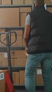 Afro-Amerikan Ayıklama Merkezi İşçi Kamyonu Online Sipariş Kutuları ile Yüklüyor. Kadın Yönetici Kulaklık Giyiyor, Tablet Bilgisayar Kullanıyor. E-Ticaret Mağazasının Depo Tesisi. Dikey Çekim