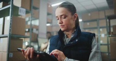 Kadın Envanter Müdürü Depo Tesisindeki Tablet Bilgisayar 'ı kullanıyor. İşçi Sınıflandırma Merkezi Karton Kutuları Nakliye için Hazırlıyor. E-Ticaret Çevrimiçi Emirleri olan Lojistik Dağıtım Merkezi. Kapat.