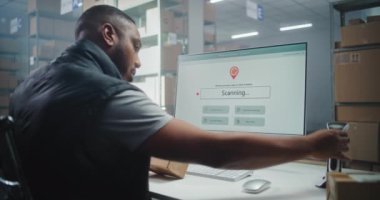 Afrikalı Amerikan Posta Deposu İşçi Tarayıcısı, Karton Kutuda Barkod Tarayıcı Kodu, Paket Bilgilerini İzler. PC Ekranı Paket Yönlendirmesini Kontrol Etmek için Sevkiyat İzleme Yazılımını Gösteriyor. Doli Vuruşu.