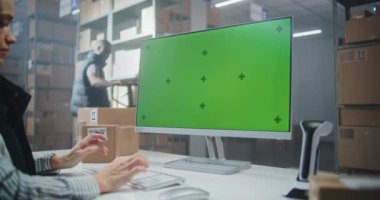 Depo Perakende Merkezi: Kadın Envanter Yöneticisi PC 'de çalışıyor, E-Ticaret Online Siparişleri ve Gıda ile Paketlerin Teslimat Bilgilerini kontrol ediyor. Yeşil Ekran Şablonlu Bilgisayar Ekranı. Doli Vuruşu.