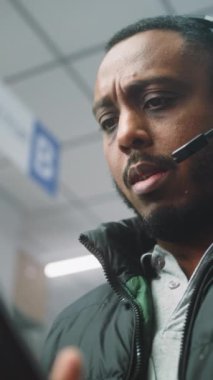 Afro-Amerikan Lojistik Koordinatörü, Kulaklık Takan Müdür Depo Tesislerinde Tablet Bilgisayar kullanıyor. E-Ticaret Çevrimiçi Emirleri olan Lojistik Dağıtım Merkezi. Yakın çekim. Dikey Çekim.