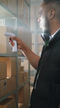 Afrikalı Amerikalı Çalışan Tarayıcı ile E-Ticari Ürünler Paketlerini Tarıyor. Kulaklıktaki Kadın Depo Şirketi Tablet Bilgisayar kullanıyor, Nakliye Bilgilerini Denetliyor. Teslimat Teslimat Merkezi.