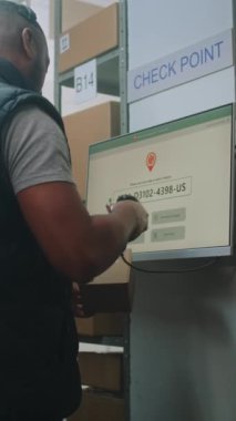 Posta Terminalindeki Afro-Amerikan Paket İşleme Uzmanı Karton Kutuları Dijital Ekranda, Paket Teslimat Bilgilerini İzleme Yazılımında Denetliyor. Çevrimiçi Siparişlerle Lojistik Merkezi