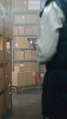 Kadın Yönetici Kulaklık Giyiyor, Tablet Bilgisayar Kullanıyor. Afrikalı Amerikalı Seçici, Palet Kamyonu Online Sipariş Kutuları ile Dolduruyor. E-Ticaret Mağazası Depo Tesisi. Dikey Çekim
