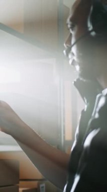 Afro-Amerikan Depo Ortaklığı Kulaklık Karton Paket Tarama Tablet Bilgisayar kullanarak Müşteriye Paket Taşıyor. Sunlight 'tan E-Ticaret Mağazası Aydınlatma Merkezi. Dikey Çekim.
