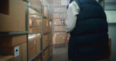 Kadın Yönetici Kulaklık Giyiyor, Tablet Bilgisayar Kullanıyor. Afrikalı Amerikalı Seçici, Palet Kamyonu Online Sipariş Kutuları ile Dolduruyor. E-Ticaret Mağazasının Depo Tesisi. Doli Vuruşu