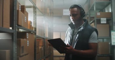 Afrikalı Amerikalı Müşteri Desteği Lojistik Uzmanı, Çağrı Kulaklığı Yöneticisi Konuşmaları Tablet Bilgisayar Kullanıyor. E-ticaret mağazasının Teslimat Servisi 'nde çalışan bir depo çalışanı. Doli Vuruşu.