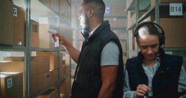 Afrikalı Amerikalı Çalışan Tarayıcı ile E-Ticari Ürünler Paketlerini Tarıyor. Kulaklıktaki Kadın Depo Şirketi Tablet Bilgisayar kullanıyor, Nakliye Bilgilerini Denetliyor. Teslimat Teslimat Merkezi.