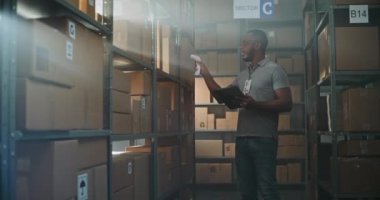 Afro-Amerikan Depo Ortaklığı, karton kutuları tarayıcı ile tarar, tablet bilgisayardaki bilgileri kontrol eder, teslimat paketini müşteriye götürür. E-Ticaret Mağazası Sıralama Merkezi. Doli Vuruşu.