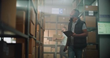 Afrika kökenli Amerikalı Envanter Yöneticisi E- Ticaret Çevrimiçi Depo Siparişleri ile birlikte karton kutuda, Tablet Bilgisayar kullanıyor, Nakliye için paket alıyor. Teslimat Hizmet Sıralama Merkezi