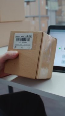 Posta Servisi çalışanı, Tarayıcı ile karton kutunun üzerindeki kodu tarar, paket bilgilerini kontrol eder. Tablet Bilgisayar Ekranı İzleme Uygulamasını İzleme Paketi Yönlendirmesini İstemciye Götür. Dikey Çekim.