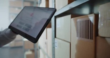 Envanter Yöneticisi Karton Kutudaki Kodu Barkod Tarayıcı ile tarar, Paket Bilgilerini Kontrol eder. Tablet Bilgisayar Ekranı Çevrimiçi Siparişlerle Paket İzleme Sistemi 'ni gösterir. Kapat.