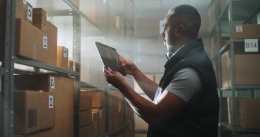 Afro-Amerikan Depo Ortaklığı Karton Kutuları E-Ticaret Online Siparişleri Tablet Bilgisayarını kullanarak, Paketler Nakliye Bilgilerini Denetler. Teslimat Hizmet Sıralama Merkezi. Doli Vuruşu.