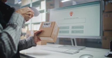 Kadın Lojistik Uzmanı, Tarayıcı ile karton kutunun üzerindeki kod, Paket Bilgilerini kontrol eder. Bilgisayar Ekranı Çevrimiçi Siparişlerle Paket İzleme Sistemi 'ni gösterir. Kapat..